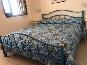 a bedroom with a bed with a blue comforter at Pensione La Nassa in Stromboli