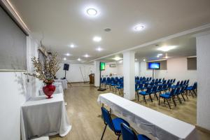 a room with blue chairs and a table with a vase on it at Hotel Metropolitano in Coronel Fabriciano
