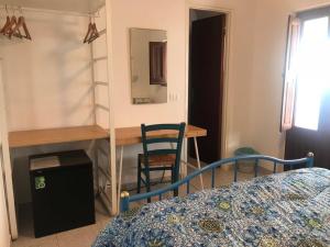 a bedroom with a bed and a desk and a mirror at Pensione La Nassa in Stromboli