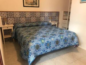 a bed room with a blue and white bedspread at Pensione La Nassa in Stromboli