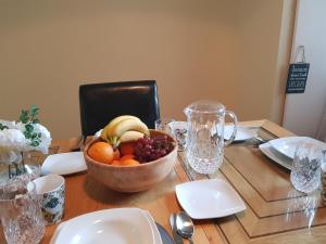 a wooden table with a bowl of fruit on it at Georgian 8 bed, 4 room, home from home in Derry Londonderry