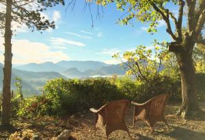 two chairs sitting on a hill with a view of mountains at La Traversière Condorcet in Condorcet