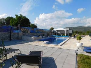 a patio with a pool and a gazebo at Vacation house Radosic in Radošić