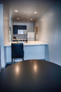 cocina con mesa y silla negra en Z Loft Extended Stay Hotel, en Saint Robert