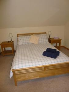 a bedroom with a bed with two nightstands and two tables at Goldenhill in Portree