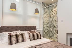 een slaapkamer met een bed met 2 kussens erop bij soho london suite in Londen