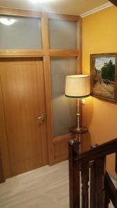 una lámpara junto a una puerta en una habitación en Pensión Casa Frade, en Arzúa
