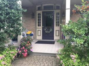 a front door of a house with flowers at Cottage on Caledonia Bed & Breakfast in Stratford