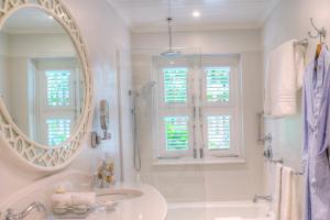 a white bathroom with a sink and a mirror at Cobblers Cove - Barbados in Saint Peter