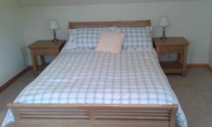 una camera con un letto con due comodini e due lampade di Goldenhill a Portree