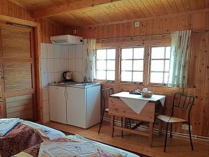 a kitchen with a refrigerator and a table in a room at Hótel Bjarkalundur in Berufjarðarvatn