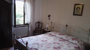 una camera con un letto e una sedia e una finestra di Sant'Antonio a Volterra