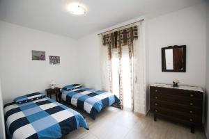 a bedroom with two beds and a dresser and a mirror at Casa da Alegria in Lagos