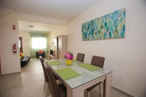 a dining room with a table and chairs and a living room at Casa da Alegria in Lagos +2 photos