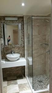 a person taking a picture of a bathroom with a sink and shower at Dreamy Airport's Apartment in Heraklio Town