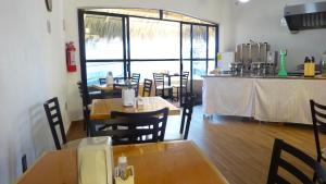 un restaurante con mesas y sillas de madera y una barra en Villas La Lupita, en Acapulco