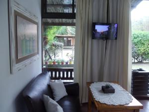 un soggiorno con divano, tavolo e TV di Dandy Suites a Mar de las Pampas