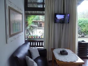 a living room with a couch and a table and a television at Dandy Suites in Mar de las Pampas