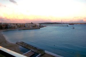 a view of a large body of water with buildings at Water's Edge Hotel in Birżebbuġa