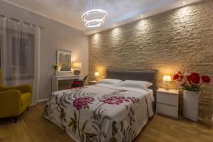 sypialnia z łóżkiem i ceglaną ścianą w obiekcie Exclusive city center apartment with garden w Rovinj