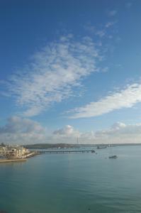 a large body of water with a bridge and a boat at Water's Edge Hotel in Birżebbuġa