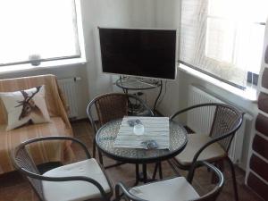 a room with a table and chairs and a television at Villa Traku Terasa in Trakai