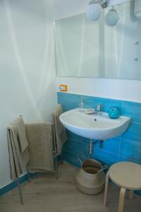 een badkamer met een witte wastafel en een tafel bij Casa del Corso in Sorrento