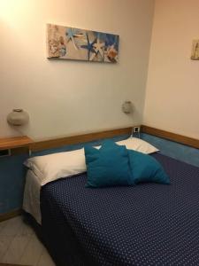 a bedroom with a bed with a blue pillow on it at Affittacamere La Baia Di Lerici in Lerici