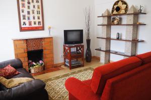 a living room with a red couch and a fireplace at Casa do Massorim in Viseu