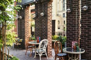 a patio with tables and chairs and a brick wall at Freehand New York in New York