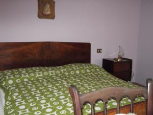 una camera con letto e piumone verde di La Panoramica a Perarolo