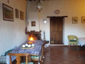 a living room with a table and a fireplace at La Campesa in Vagliagli