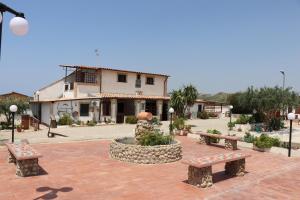 a group of benches in front of a building at Casa Vacanza Villa Sole Montallegro in Siculiana