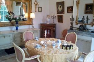a room with a table with chairs and a mirror at Chateau du Mesnil in La Vieille-Lyre