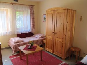 ein Schlafzimmer mit einem Bett und einem großen Holzschrank in der Unterkunft Foki Apartman in Sopron-Balf