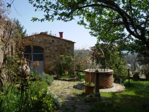 a garden with a stone building and a stone path at La Campesa in Vagliagli +11 photos
