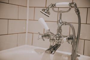 a bathroom sink with a faucet and a toilet paper at The Falkland Arms in Chipping Norton