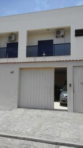 a building with a garage with a car parked in it at Casa e Suites in Aparecida