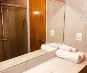 Baño con 3 toallas en una encimera frente a un espejo en Estudio Dalia vista para o mar, en Río de Janeiro