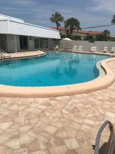 a large swimming pool with chairs and a building at Crescent Arms 105N in Sarasota
