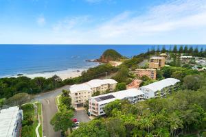 a beach with a view of the ocean and mountains at Flynns Beach Resort in Port Macquarie