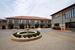 a building with a fountain in the middle of a courtyard at Europrime Hotel in Boksburg