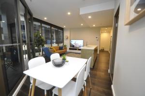 uma sala de jantar e cozinha com uma mesa branca e cadeiras em Orange Stay Sydney CBD em Sidney