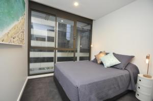um quarto com uma cama e uma grande janela em Orange Stay Sydney CBD em Sydney
