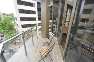 duas cadeiras sentadas numa varanda de um edifício em Orange Stay Sydney CBD em Sidney