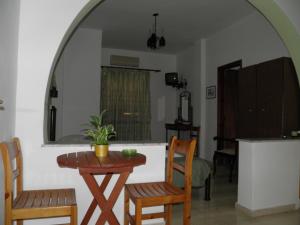 a dining room with a table and chairs and a kitchen at Mirsini Pansion in Karterados