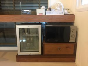 a microwave sitting on top of a counter next to a shelf at Clear House Resort - SHA Extra Plus in Kamala Beach