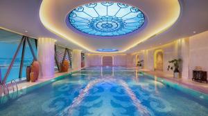 a swimming pool with a ceiling with a stained glass window at Wanda Reign Wuhan in Wuhan