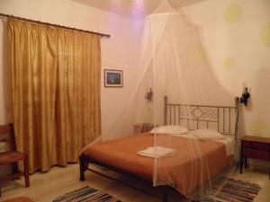 a bedroom with a bed with a canopy at Mirsini Pansion in Karterados
