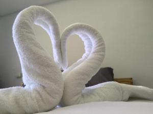 two towels shaped like swans sitting on a bed at Valee home & food in Nakhon Nayok